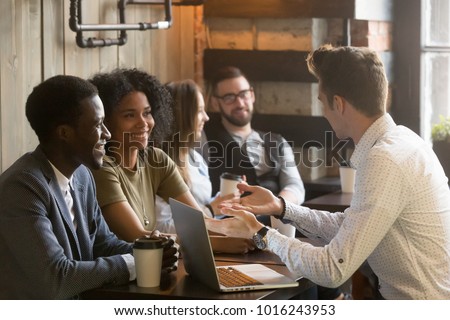 Insurance salesman or mortgage broker consulting young african american couple in cafe, caucasian realtor making offer explaining deal details to smiling black customers at meeting in coffee house