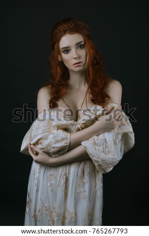 https://thumb1.shutterstock.com/display_pic_with_logo/2794339/765267793/stock-photo-a-young-beautiful-red-haired-woman-in-a-long-vintage-gold-dress-posing-on-a-black-background-a-765267793.jpg