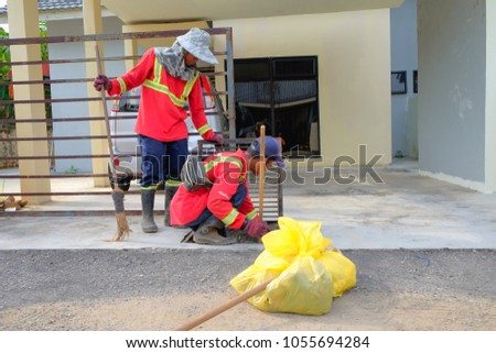 Muadzam Shah, Malaysia - March 22nd, 2018: Municipal workers "Alam Flora" uses sweepers and shovels to clean the garbage in the drain and put into the garbage bag.