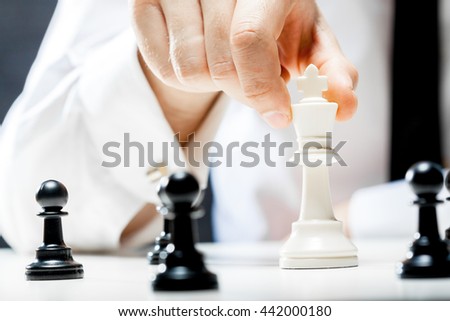 Hand of businessman playing chess
