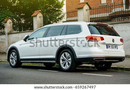 PARIS, FRANCE - MAY 28, 2017: View from below of white Volkswagen Passat Alltrack all four wheel drive car parked in city. Alltrack bridges the gap between the passenger VW range and the SUV range