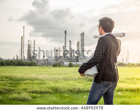 the sunlight to refinery engineer with engineer white safety helmet see drawing engineering in oil refinery building engineer structure in engineer heavy petrochemical refinery engineer industry.