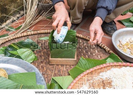 Hand stuffing Chung Cake in square shape with glutinous rice, split mung beans, chunks of pork shoulder, salt, pepper, ginger. It is packed as tight as possible to keep cake from mold or spoiled.