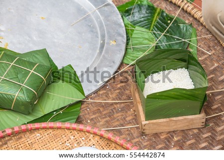 Chung Cake ingredients, tool preparation wrapping. Square shape wood mold with glutinous rice, split mung beans, chunks of pork shoulder, salt, pepper, ginger, bamboo, banana leaves, long node string.