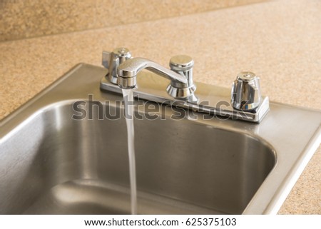 stainless steel kitchen sink and faucet on a yellow granite worktop decoration water flowing from - American Kitchen Sink stainless steel kitchen sink and faucet on a yellow granite worktop decoration water flowing from - American Kitchen Sink