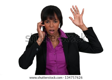 A black businesswoman angry over the phone.