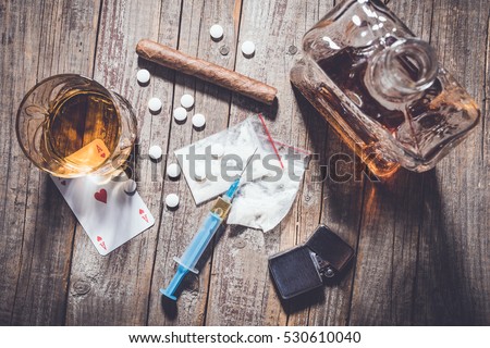 Hard drugs and alcohol on an old wooden table