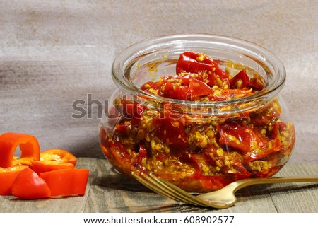 A jar of red chili pickle marinated in mustard seeds, and mustard oil and Indian pickling spices