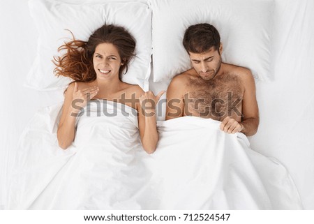 https://thumb1.shutterstock.com/display_pic_with_logo/2936380/712524547/stock-photo-high-angle-view-of-married-couple-having-problem-in-bed-handsome-man-looking-under-blanket-at-his-712524547.jpg