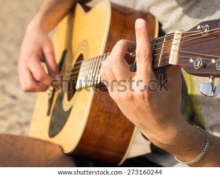 https://thumb1.shutterstock.com/display_pic_with_logo/2950702/273160244/stock-photo-young-man-playing-an-acoustic-guitar-on-the-beach-273160244.jpg