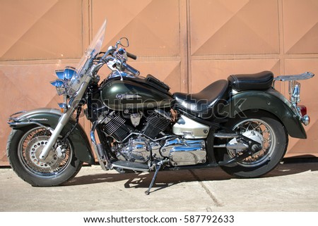 Subotica, Serbia-February 25,2017:Green Yamaha DragStar 1100 motorcycle in front of the garage, photographed on a nice sunny day. Ready for restoration. Lot of chrome detail.