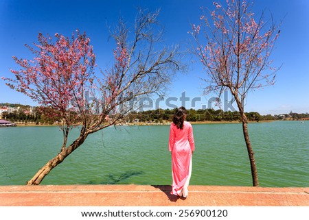 Young woman in Vietnamese traditional long dress (Ao dai) by Ho Xuan Huong Lake, Da Lat Provine, Viet Nam