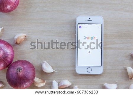 Friday, 24 March 2017: in Chiang Mai Thailand, Google application is launching on Smartphone on wooden kitchen table.