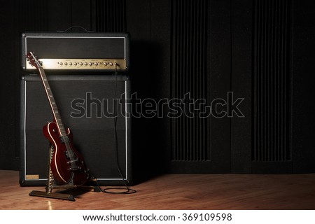 Red electric guitar and classic amplifier on a dark background