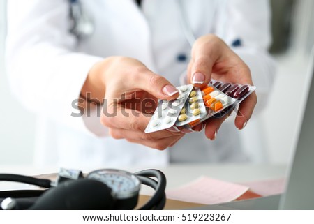 Female doctor hand holding pack of different tablet blisters at workplace closeup. Panacea, life save service, prescribe medicament, legal drug store, disease healing, blood pressure concept
