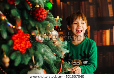 The beautiful girl decorates a Christmas Tree