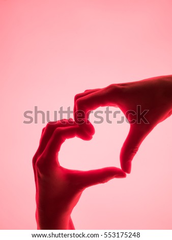 Hands in the form of heart red background. heart symbol with hand. valentines day card. Woman's hands silhouette in form of heart. hand Gestures