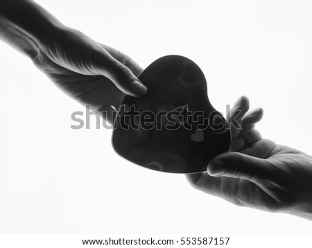 Silhouette hands. Present in man's and woman hands in the form of heart white background. Heart symbol with hand. Valentines day present. The man gives a woman a gift