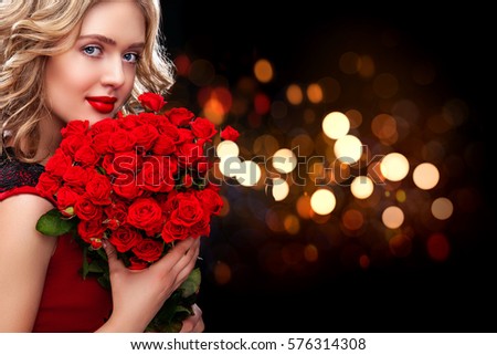 Beautiful blonde woman holding bouquet of red roses on bokeh background. Saint Valentine and International Women's Day, Eight March celebration.