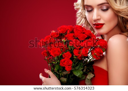 Beautiful blonde woman holding bouquet of red roses. Saint Valentine and International Women's Day, Eight March celebration.