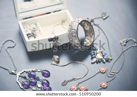 A collection of vintage jewelry in antique wooden jewelry box