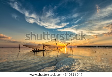 In Dong Nai, Vietnam - November 15th, 2015: Family of fishermen repairing nets on river, boating wife, husband checked to mend nets in Tri An, Dong Nai, Vietnam