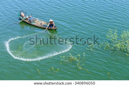 In Dong Nai, Vietnam - November 15th, 2015: The fishermen casting their nets to catch fish circle improves a better life in the winter morning at Tri An, Dong Nai, Vietnam.