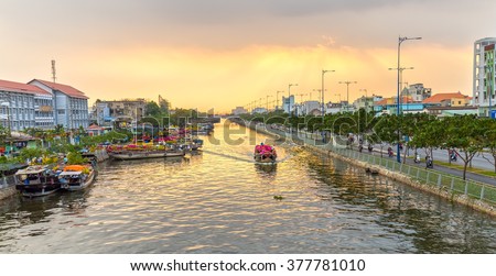Ho Chi Minh City, Vietnam - February 6th, 2016: Boat on river carry flowers to sell in afternoon sun rays beautiful, boat parked left busy selling flowers fun spring day in Ho Chi Minh city, Vietnam
