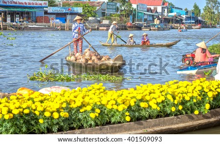 Soc Trang, Vietnam - February 2nd, 2016: Farmers selling coconut boating on river busiest air boats back forth, front bright yellow daisies boatload real river scene beauty in Soc Trang, Vietnam