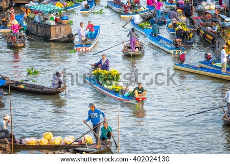Soc Trang, Vietnam - February 3rd, 2016: Couple sold daisies boatman, watermelon, many boats around the busiest crossing in morning floating market on river in the countryside in Soc Trang, Vietnam