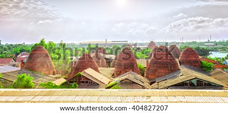 Brickyard village panoramic view from above with dozens brick kiln rise as giant mushroom in sky beautiful sunny morning, this very constructive effort workers in craft villages in Vinh Long, Vietnam