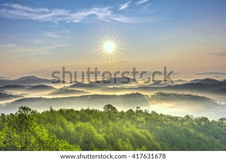 Sunrise over hill with the sun radiating golden rays pierced the hills with pine trees covered with morning dew beautiful ray beam forming to welcome the new day so simple in Da lat, Vietnam