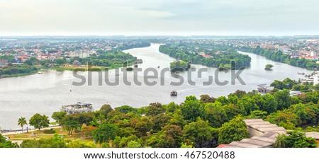 Peaceful scenery on river with boat glides on water, distance small houses with red tile roofs, river turn right back from making a painting of Hue ancient capital poetic today