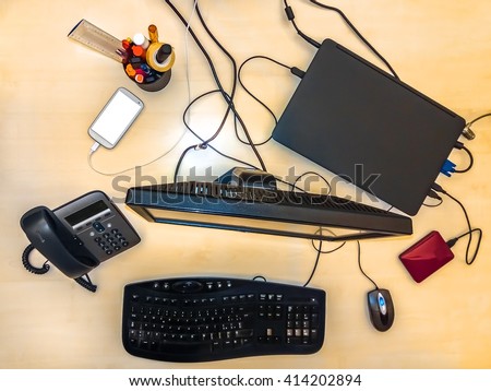 Flat lay of a business desktop with accessories:  computer,  keyboard,  monitor,  mouse,  tablet,  smartphone,  pen holder,  desk phone and a hard disk.