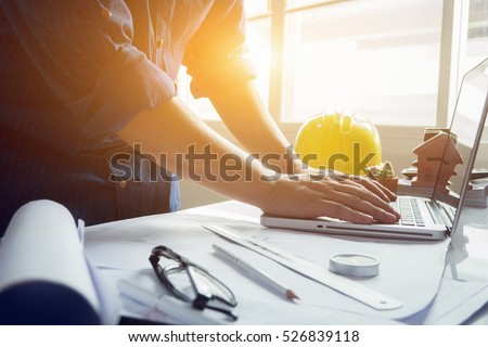 architect man working with laptop and blueprints,engineer inspection in workplace for architectural plan,sketching a construction project ,selective focus,Business concept vintage color