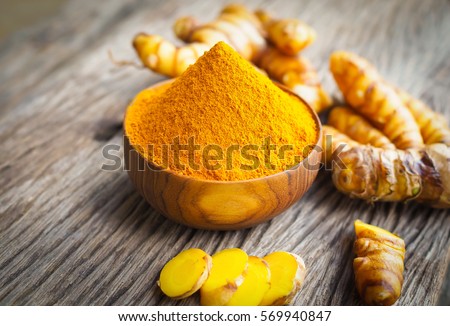Turmeric powder in wood bowls on wooden table. herbal