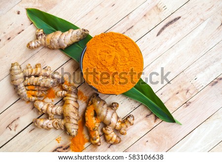 Turmeric powder in bowls on wooden table. herbal