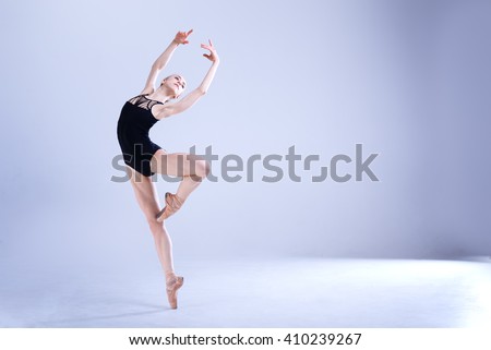 Young and incredibly beautiful ballerina is posing and dancing in a white studio full of light. The photo greatly reflects the incomparable beauty of a classical ballet art.