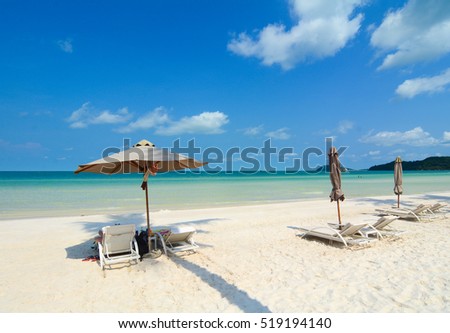 Idyllic tropical beach with relaxing chais and umbrella in sunny day