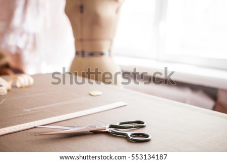 Still life photo of a suit pattern template with tape measure, chalk and scissors. Sewing and tailoring tools and accesories.