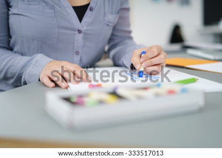Female Cartoonist Draw Something on a White Paper Using Crayons at the Table Inside the Office.