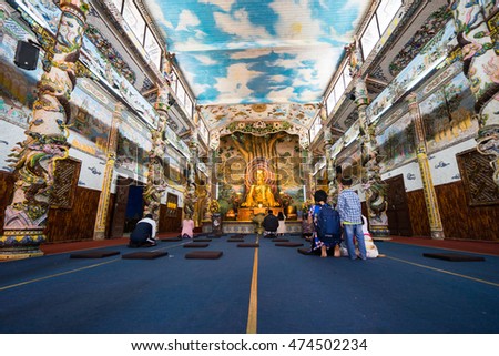 NHA TRANG, VIETNAM - JUNE 23, 2016: View of the Buddhist temple. Walls are laid out by a color mosaic. In the middle there is big gold statue of Buddha.