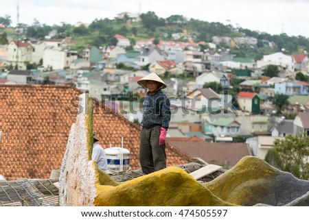 NHA TRANG, VIETNAM - JUNE 23, 2016: Asian man is standing on a roof on the background of cityscape in Vietnam