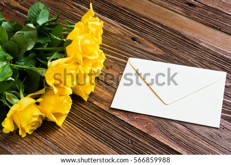 The bouquet of beautiful fresh yellow roses lies on a wooden table.
Card template by St. Valentine's Day or the international Women's Day.