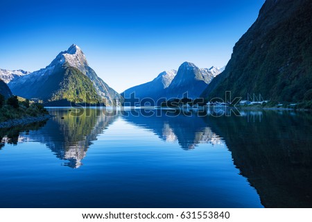 Clear sky in Milford sound, Fjordland national park, south island, New Zealand with a reflection of Mitre peak in the water.