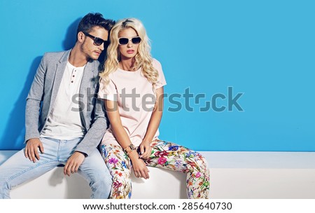 Young fashionable couple on blue background