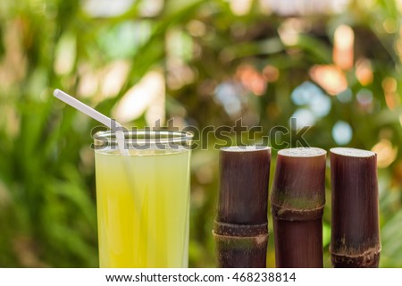 Sugarcane juice with piece of sugarcane on wooden background