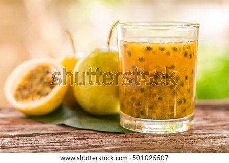 Passion fruit - Passion fruits half and juice with leaves on the vintage wooden background. Closeup, Select focus.