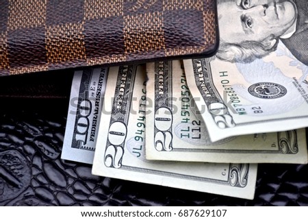 WASHINGTON DC, USA - JULY 31, 2017: Louis Vuitton mens wallet filled with cash.