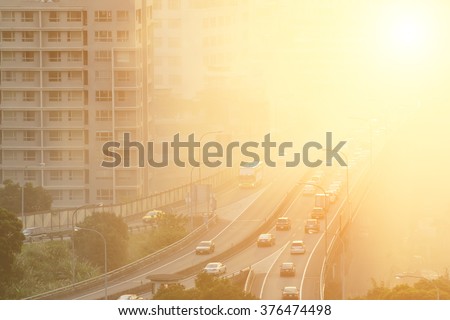 Air pollution scenic with cars on highway and yellow smoke in city.